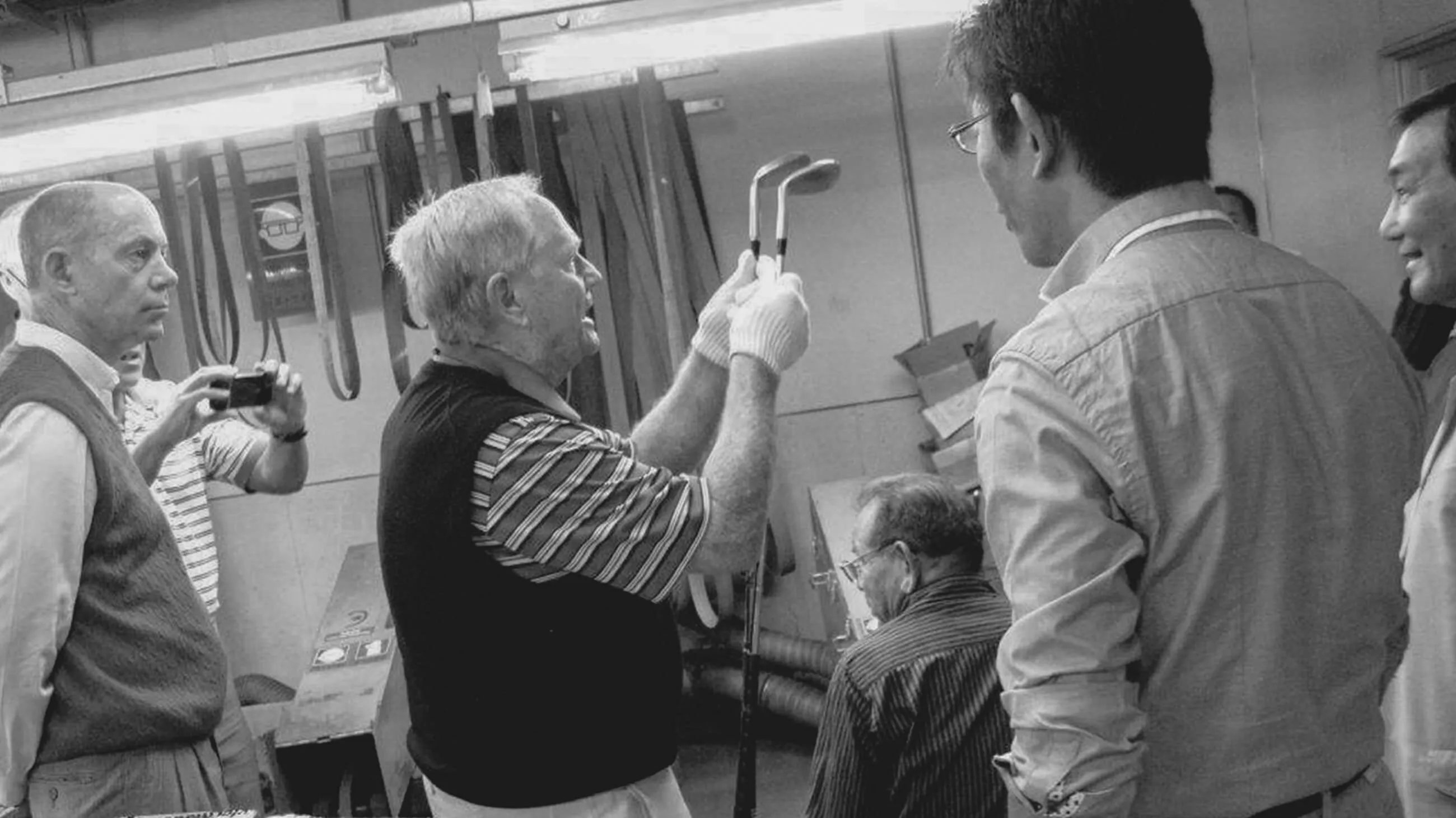Jack Nicklaus holding two clubs at the factory