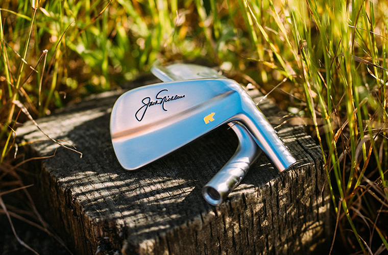 Golf iron heads sitting on wood